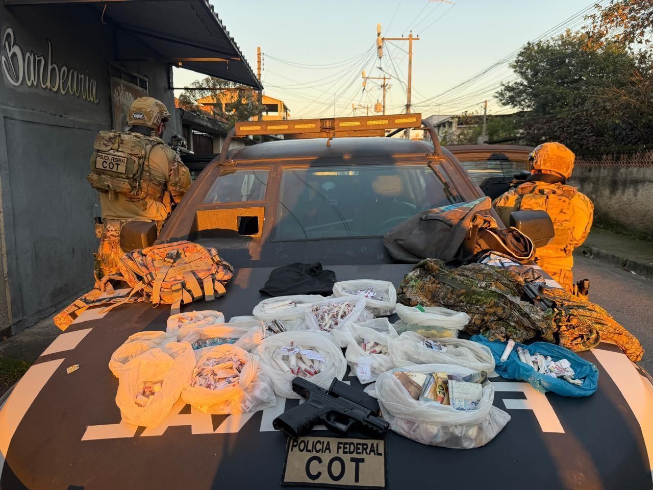 Armas, drogas, munições, radiocomunicadores e roupas táticas apreendidas com os dois traficantes presos, em flagrante, durante deslocamento das equipes para cumprimento dos mandados na ação do Jardim Catarina, em São Gonçalo (RJ) • Reprodução - PF