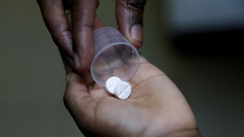 Enfermeira entrega medicamento ARV (antirretroviral), usado para impedir a replicação do HIV, a uma criança em orfanato no distrito de Karen, em Nairóbi, Quênia