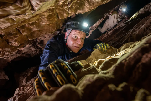 O paleoantropólogo Lee Berger faz a subida difícil pela passagem principal da Caverna Rising Star. O sistema labiríntico se estende por mais de 4 quilômetros (2,5 milhas) e tem uma profundidade vertical de 100 metros (328 pés) • Robbie Shone/National Geographic