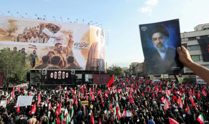 Um participante do funeral segura uma foto do Líder Supremo Mojtaba Khamenei durante o cortejo fúnebre do falecido Aiatolá Ali Khamenei em Teerã, Irã, na segunda-feira