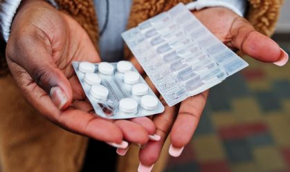 Hands of african american woman show pills.