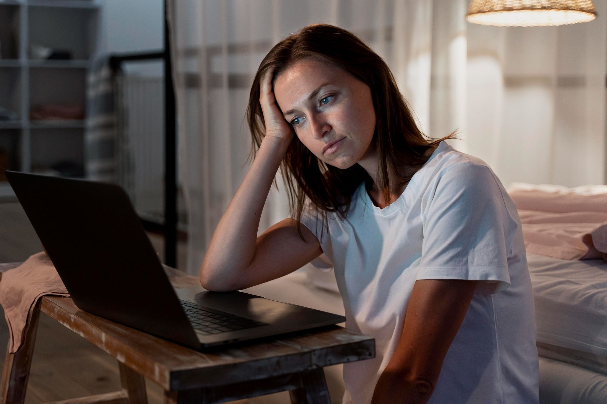 jovem-triste-usando-laptop-no-quarto