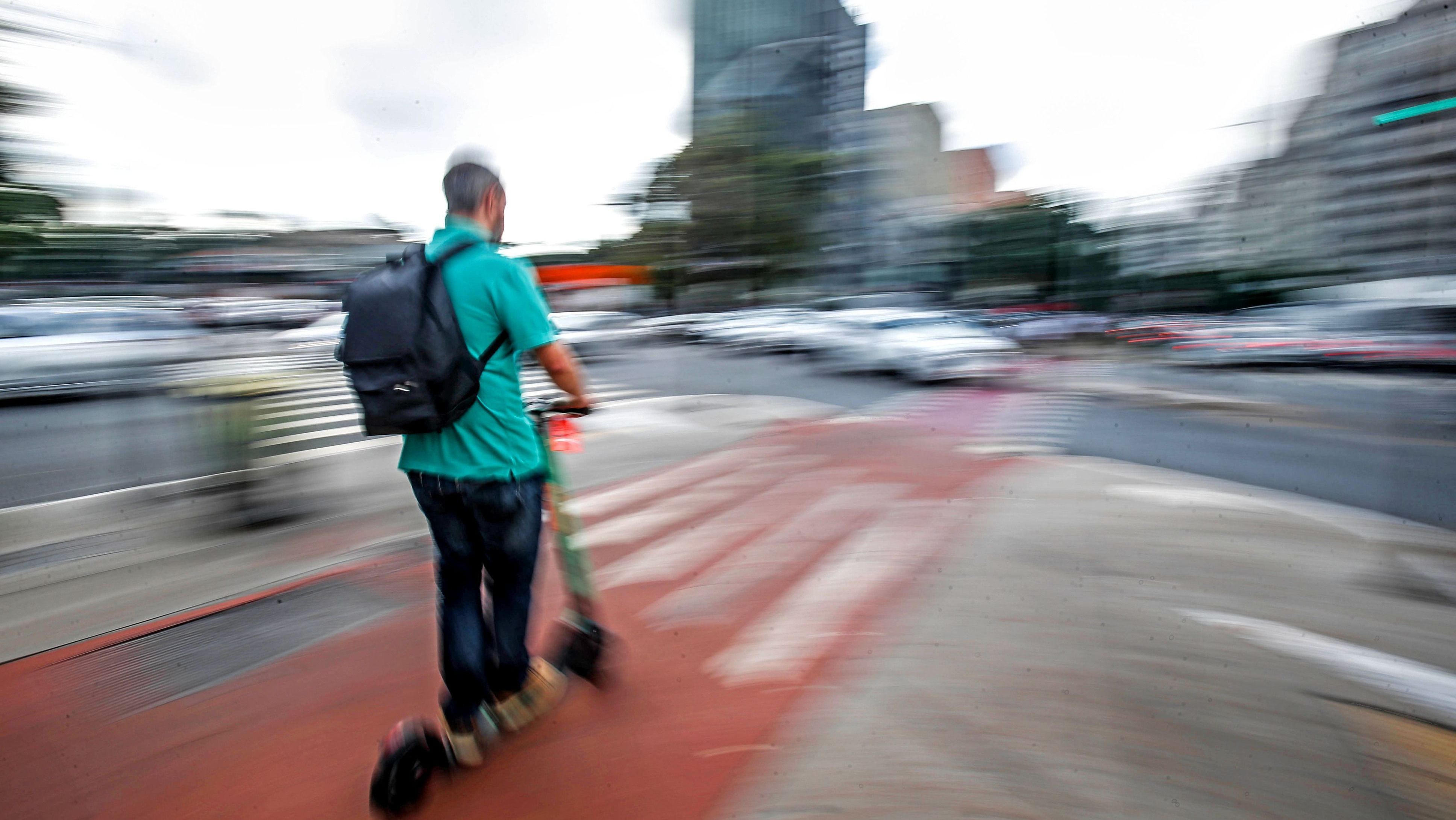 Homem andando de patinete