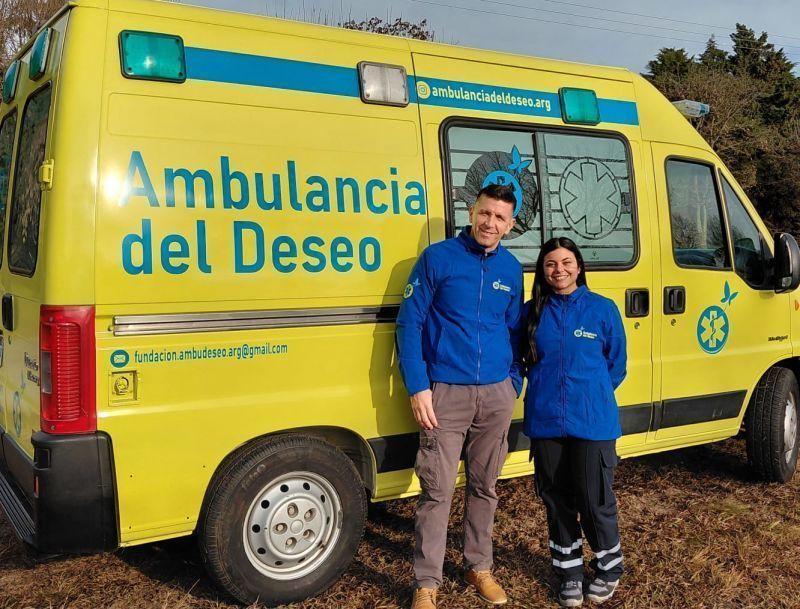 Dois voluntários da Fundação Ambulância do Desejo posam em frente à ambulância na cidade de Rosário, Argentina.