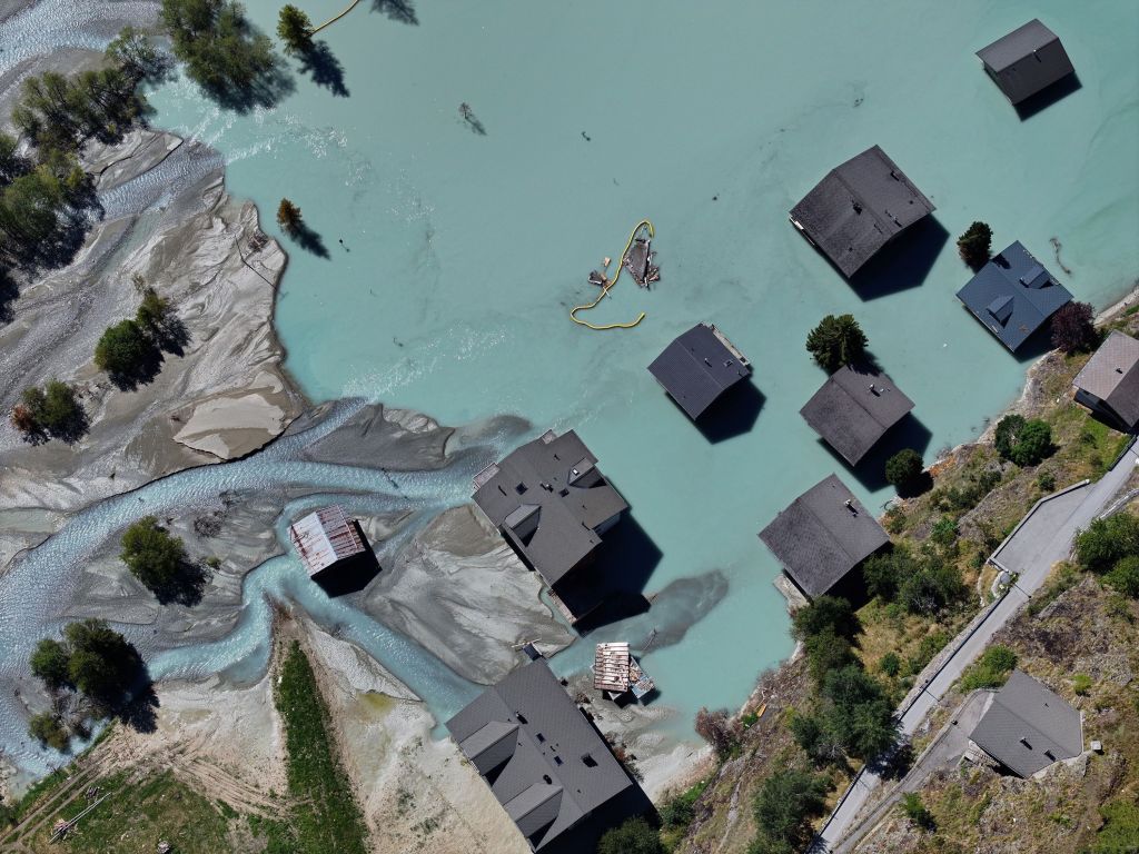 Casas submersas em água que chegou em 24 de agosto de 2025 a Blatten, na Suíça. Em 28 de maio, milhões de metros cúbicos de rocha desabaram da montanha Kleiner Nesthorn sobre a geleira Birch, lançando rochas, gelo e lama no vale.