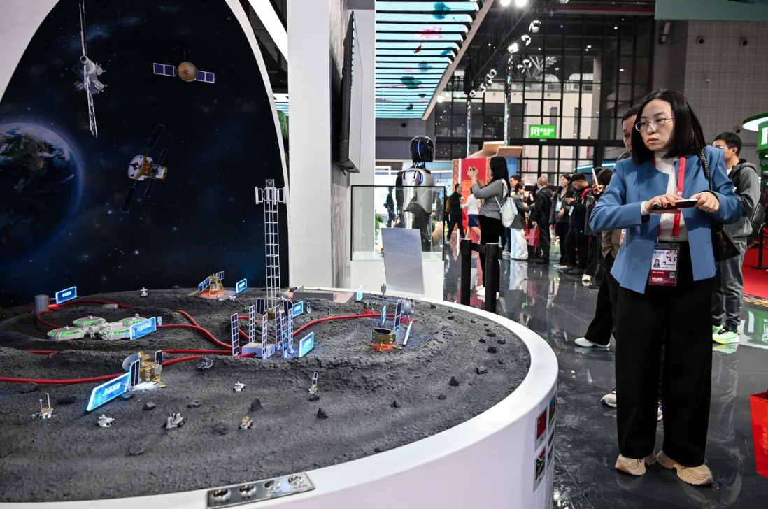 Visitantes observam uma maquete da Estação Internacional de Pesquisa Lunar no pavilhão da China durante a 8ª Exposição Internacional de Importação em Xangai, em 2025 • Héctor Retamal/AFP/Getty Images