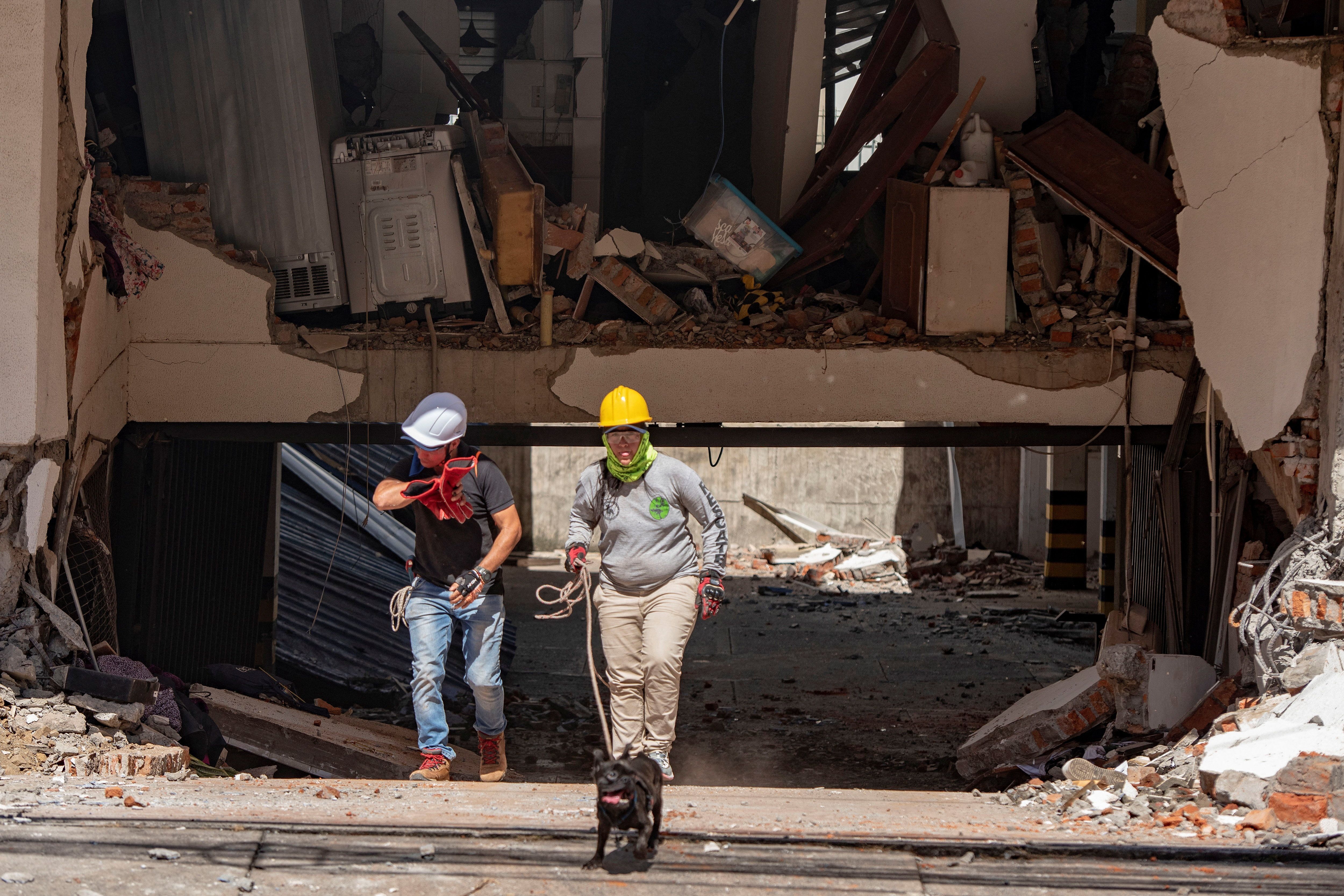 Equipes de resgate passam por um prédio danificado após um terremoto, em Cali, na Colômbia