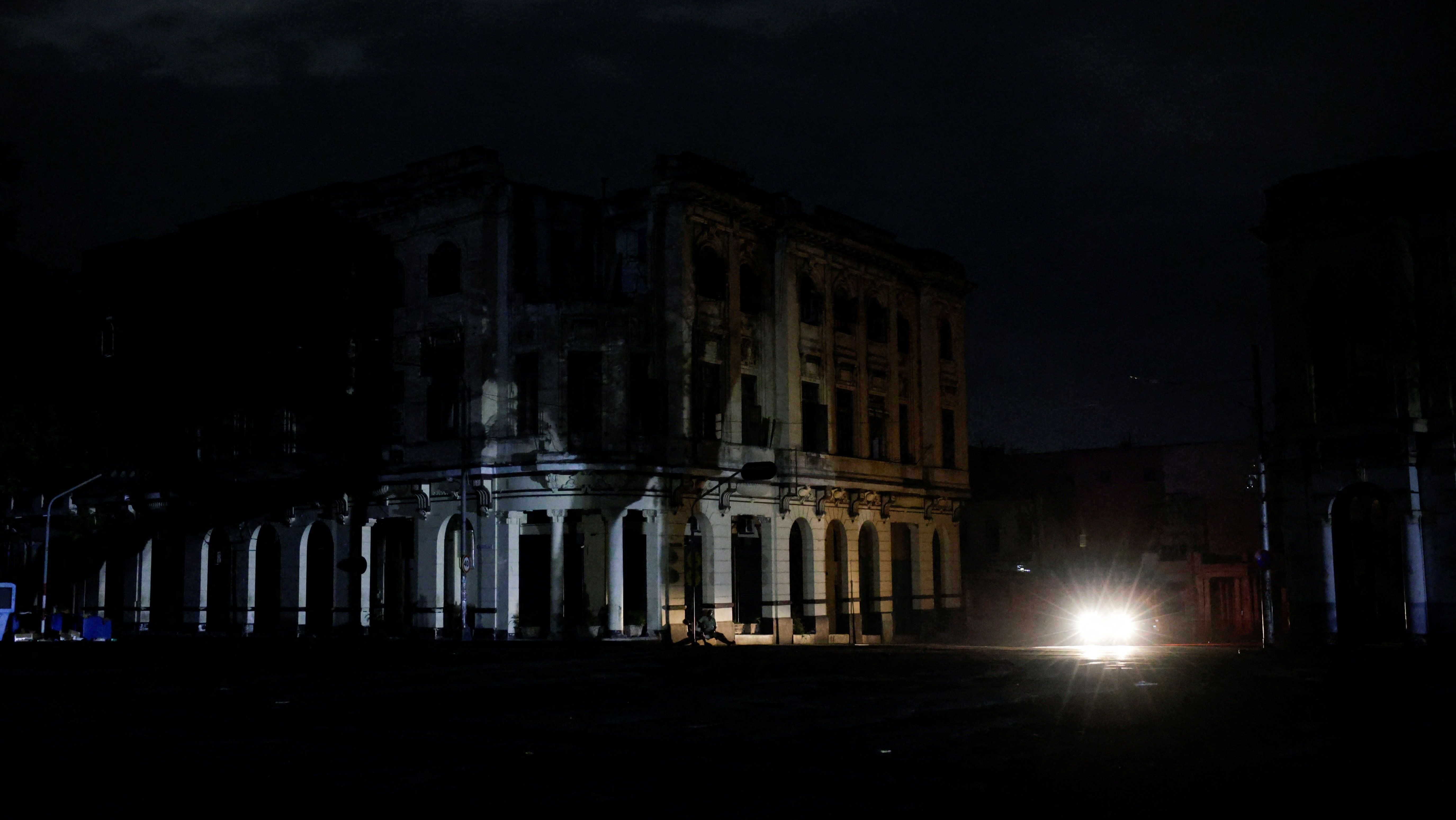 Carro ilumina fachada de prédio em meio a apagão em Havana, Cuba