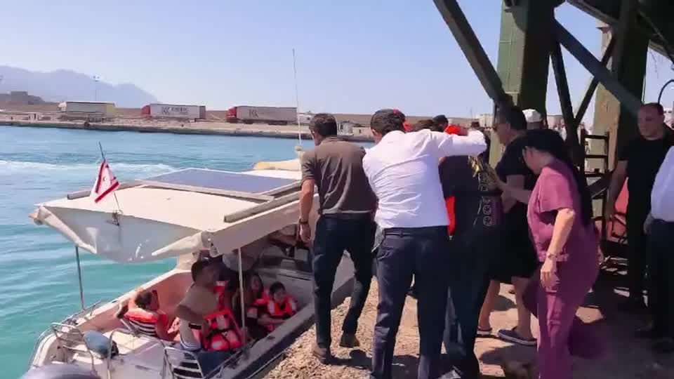 Sobreviventes usando coletes salva-vidas em embarcação naufragada