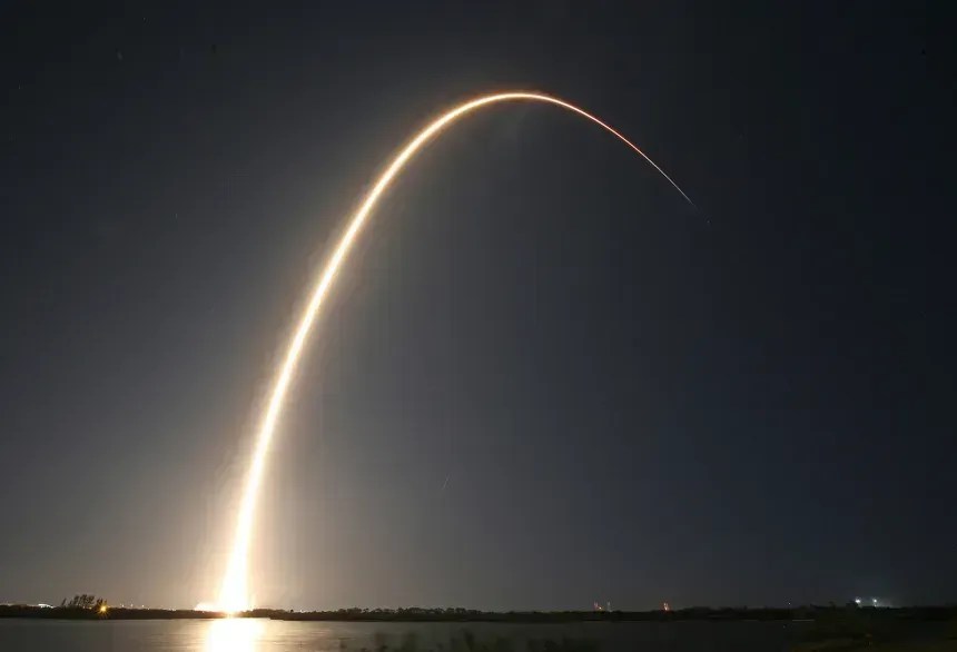 O foguete Falcon 9 da SpaceX é visto descrevendo um arco no céu após a decolagem em 2025 • Gregg Newton/AFP/Getty Images