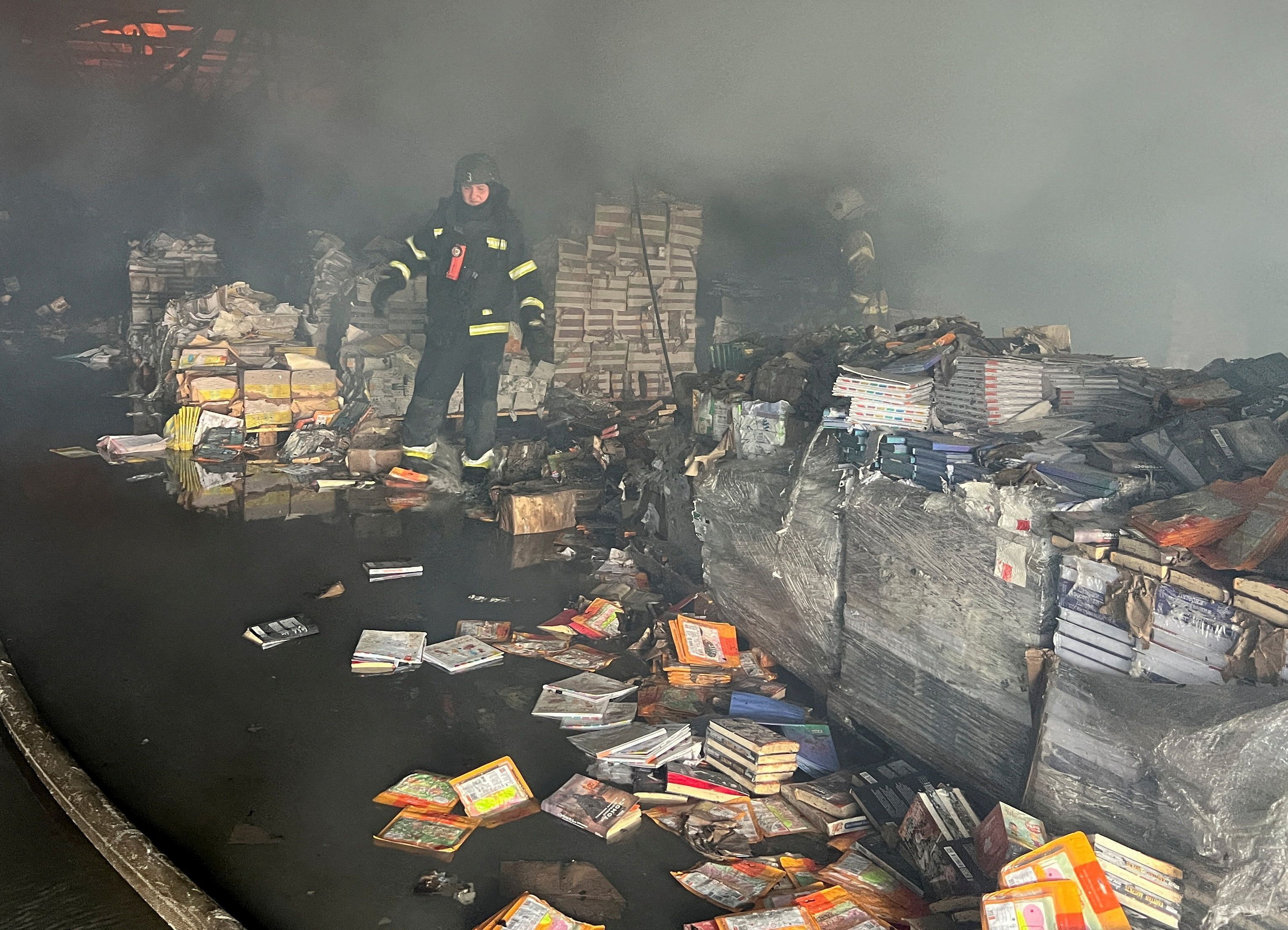 Bombeiro trabalha em depósito de livros atingido por ataque russo em Kharkiv
