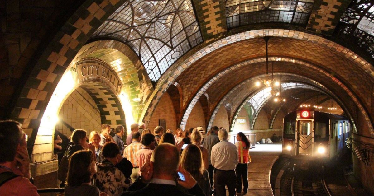 Interior da estação de metrô City Hall com arcos ornamentados e vitrais