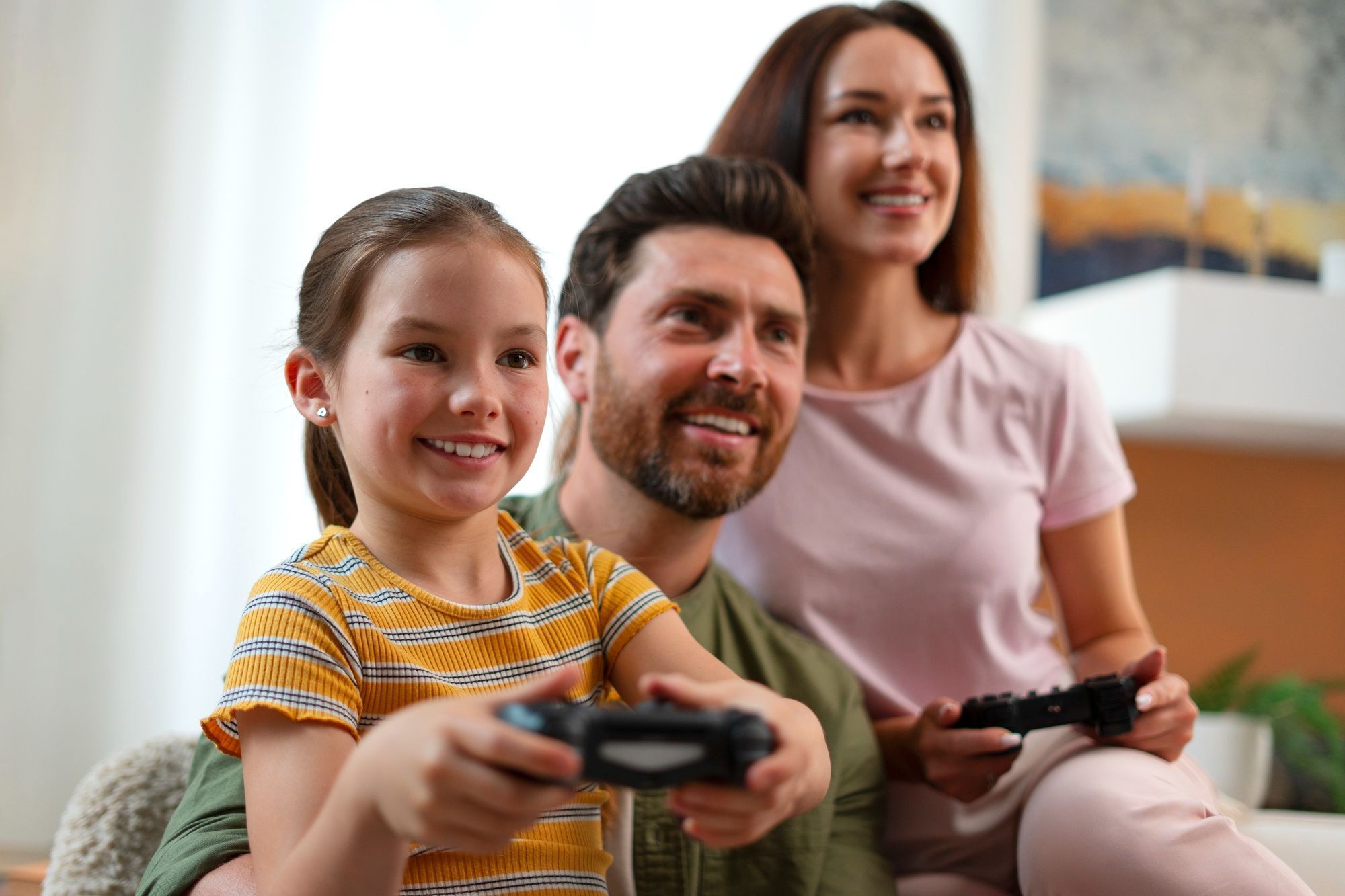 casal-jogando-videogame-com-a-filha-pequena