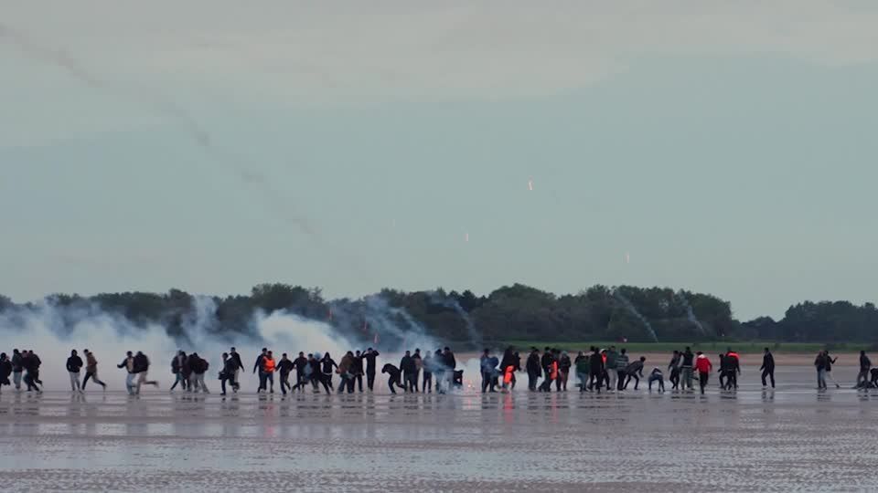 A polícia lançou gás lacrimogêneo contra migrantes em uma praia francesa. • REUTERS