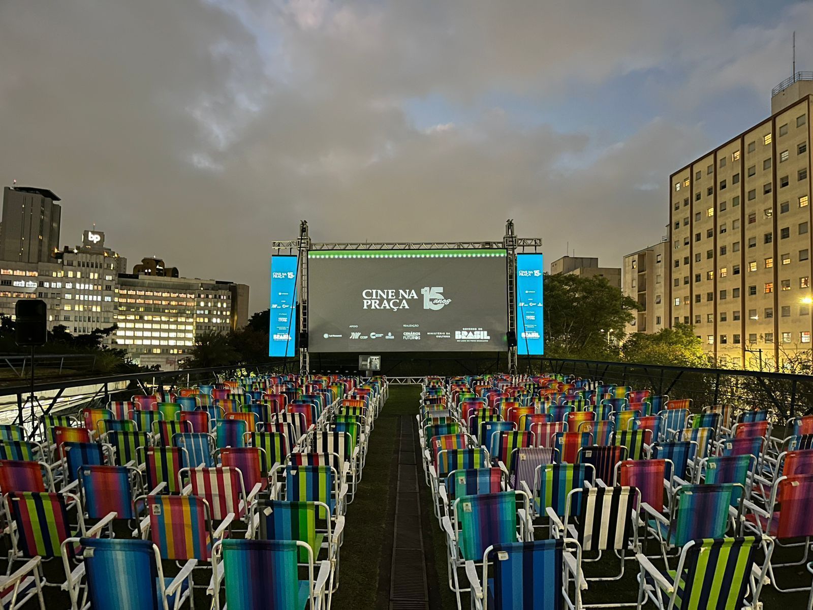 Imagem das cadeiras perfiladas diante de um telão em uma praça