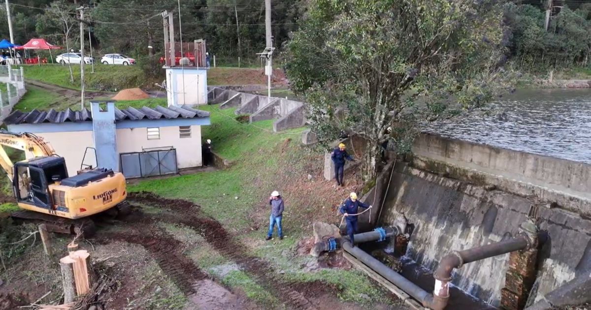 Imagem de barragem com fissuras sendo monitorada por equipes técnicas