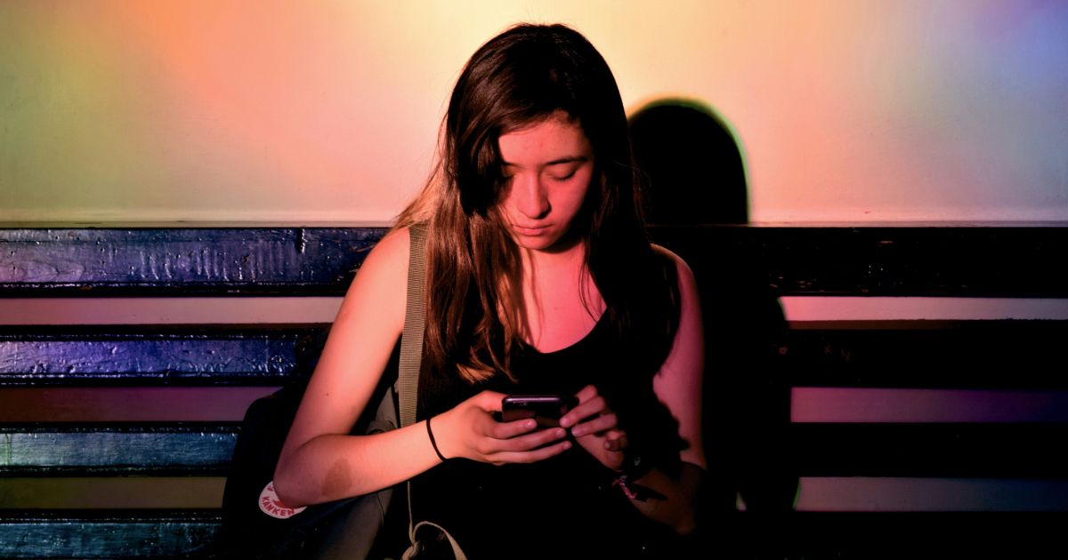 Pessoa olhando para celular com expressão triste