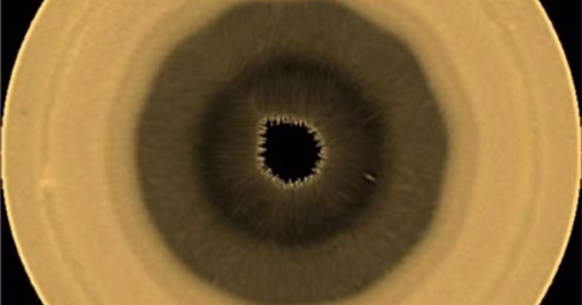 Imagem artística de Saturno com destaque para o polo sul e a formação de dez lados