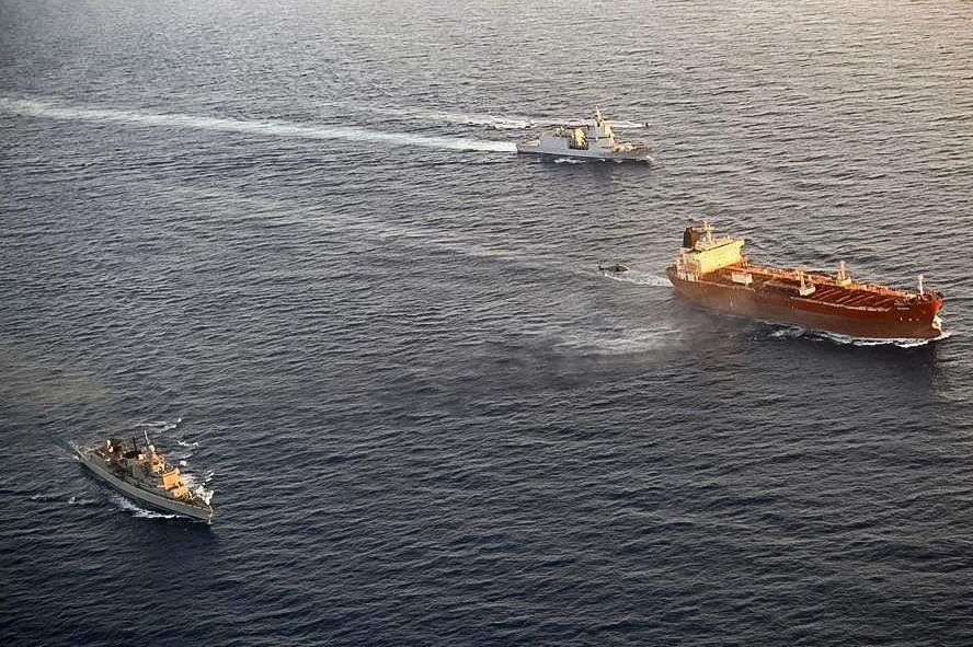 Helicóptero militar italiano sobrevoa o petroleiro Toa Payoh, em primeiro plano, enquanto o navio da Marinha italiana Thaon di Revel navega nas proximidades durante uma inspeção da missão EUNAVFOR MED IRINI da União Europeia em águas internacionais a oeste da ilha italiana de Pantelleria, em 2 de agosto de 2026