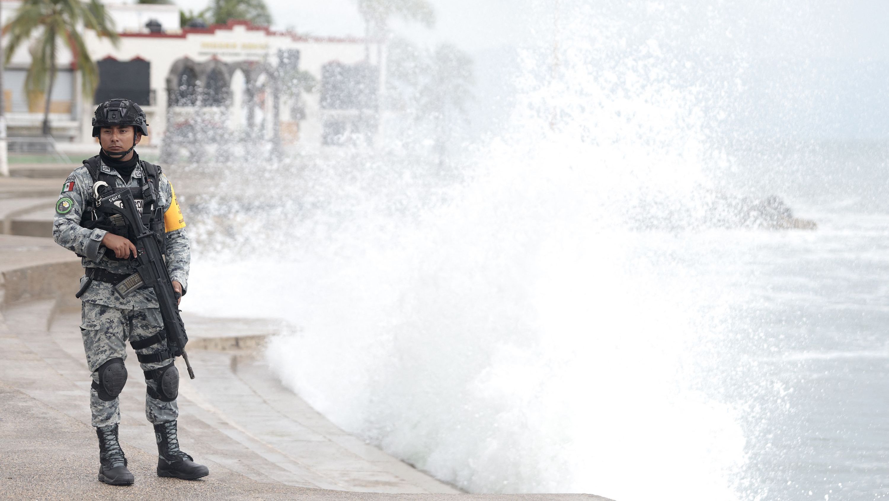 Um membro da Guarda Nacional do México permanece no calçadão de Puerto Vallarta enquanto as ondas quebram contra a costa, antecipando o possível impacto do furacão Simon em Puerto Vallarta, estado de Jalisco, México, em 11 de outubro de 2026.