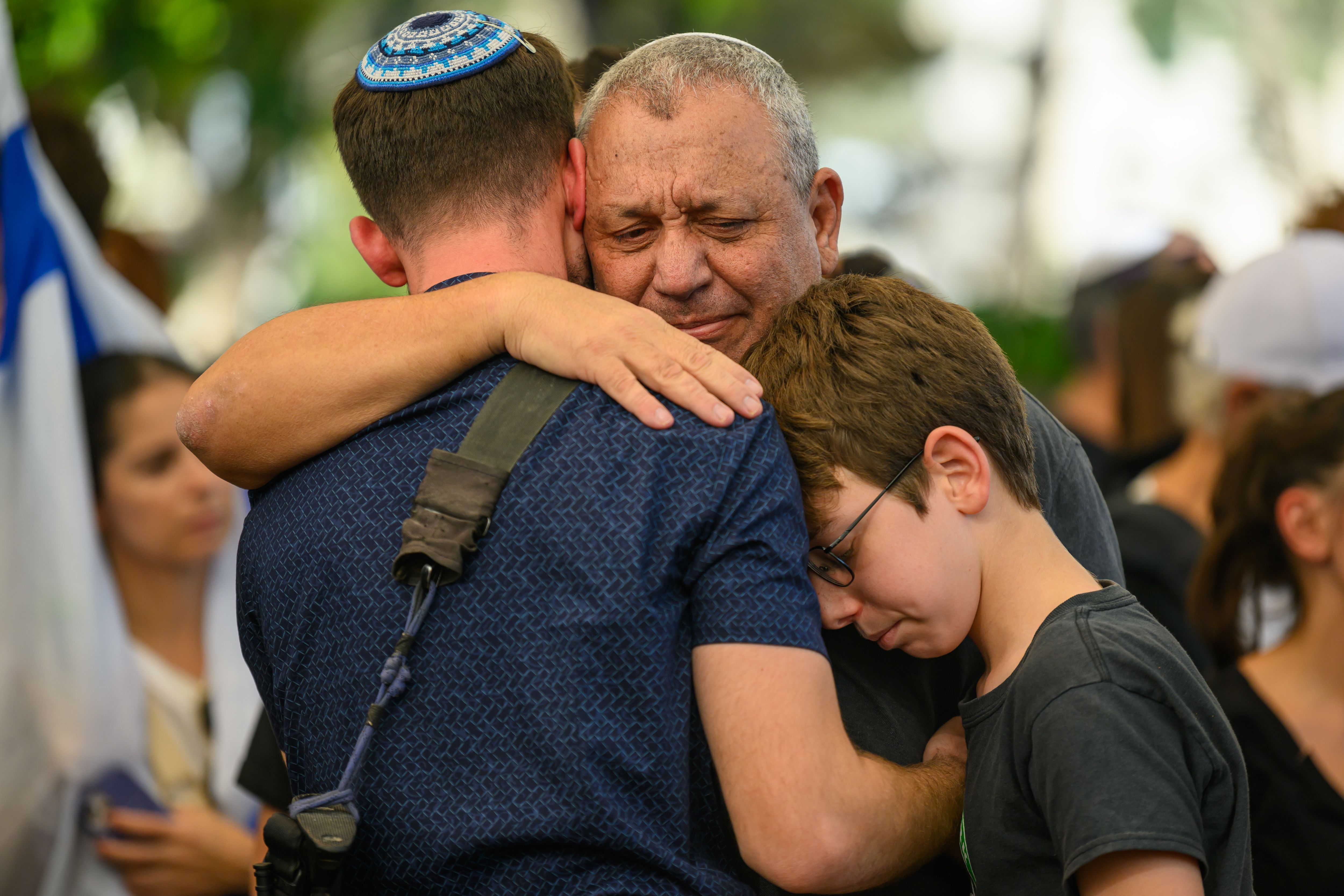 O ex-Chefe do Estado-Maior das Forças de Defesa de Israel (FDI), Tenente-General (da reserva) Gadi Eisenkot (ao centro), abraça familiares e amigos durante o funeral do Primeiro-Sargento-Major Gal Meir Eisenkot (25 anos), no cemitério de Herzliya, em 8 de dezembro de 2023, em Herzliya, Israel • Foto de Alexi J. Rosenfeld/Getty Images