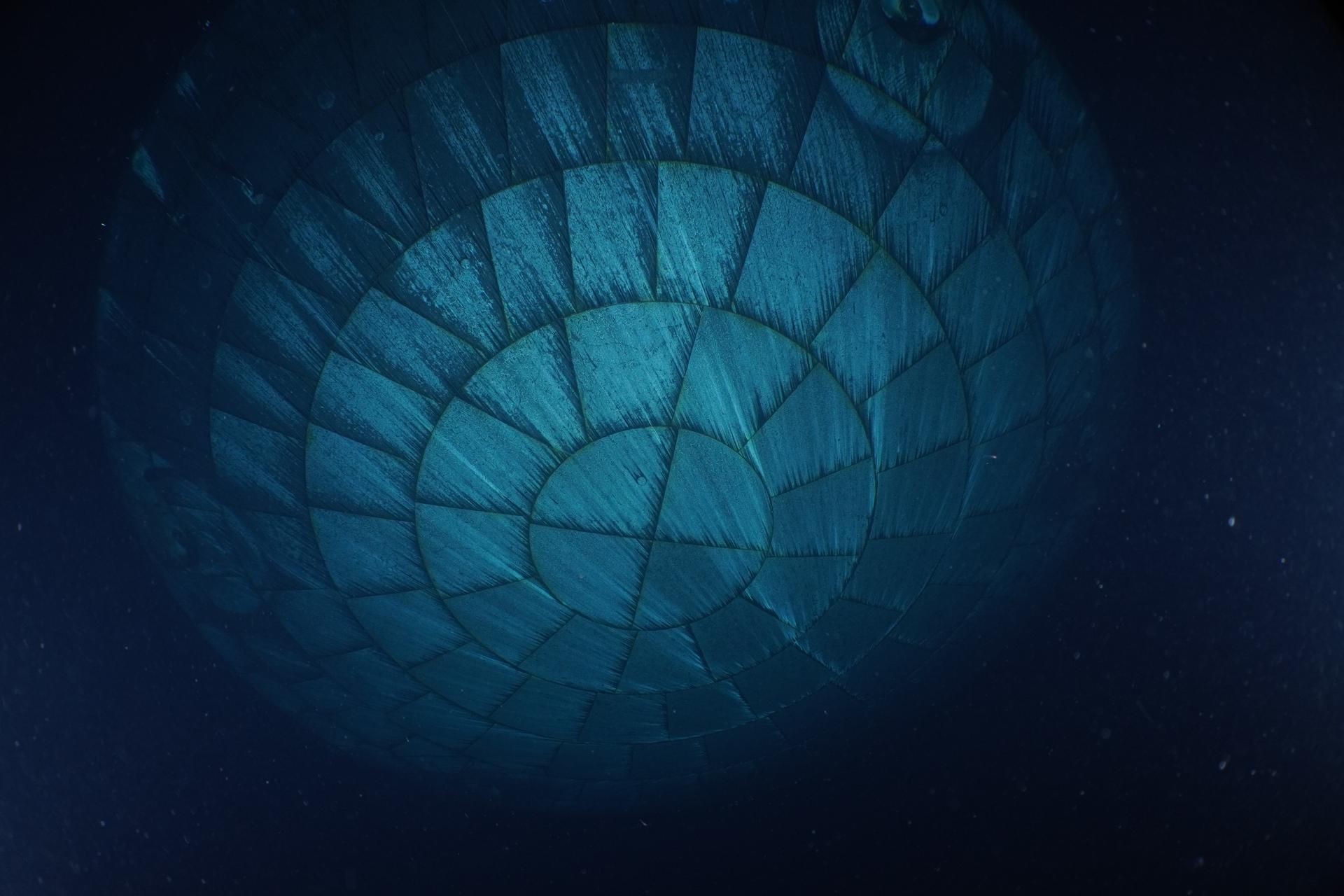 Pouco depois do pouso da Artemis II no mar, em 10 de abril de 2026, mergulhadores da Marinha dos EUA capturaram imagens subaquáticas do escudo térmico da espaçonave Orion • Marinha dos EUA