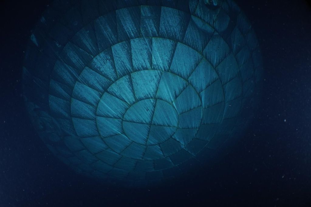 Pouco depois do pouso da Artemis II no mar, em 10 de abril de 2026, mergulhadores da Marinha dos EUA capturaram imagens subaquáticas do escudo térmico da espaçonave Orion