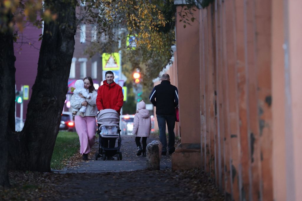 Pessoas caminham em frente à cerca do prédio do Instituto de Pesquisa Anti-Peste da Sibéria e do Extremo Oriente de Irkutsk, na Rússia, nesta quarta-feira.