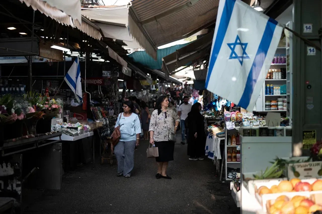Pessoas caminham por uma área de mercado em Tel Aviv em 25 de outubro