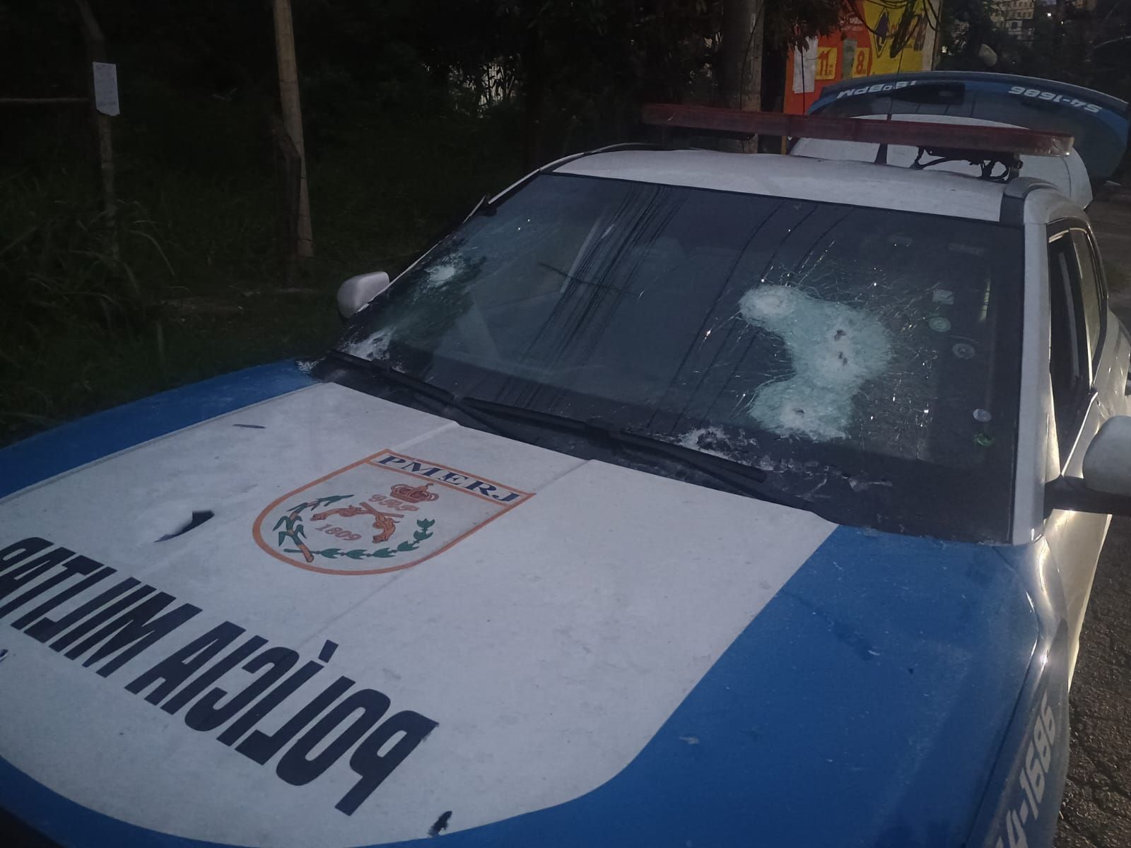 Viatura policial foi atingida por disparos durante o confronto entre equipes da Polícia Militar na comunidade Gardênia Azul, na Zona Sudoeste do Rio, na manhã deste domingo (11). • Reprodução - Redes Sociais