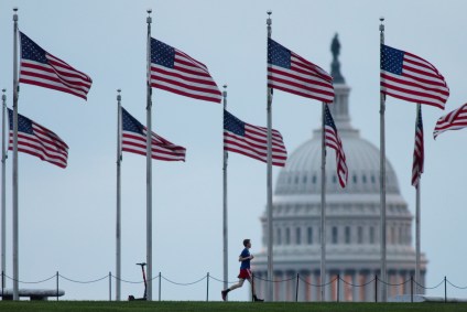 Pessoa corre pelo Monumento a Washington perto do Capitólio, em Washington