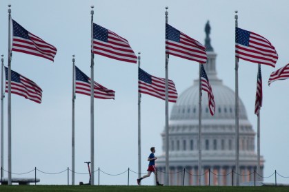 Pessoa corre pelo Monumento a Washington perto do Capitólio, em Washington