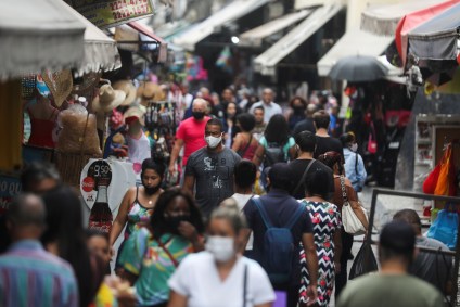 Pessoas caminham em rua de comércio popular no Rio de