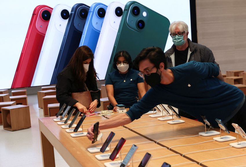 Apple Store em Nova York / FOTO DE ARQUIVO: Um funcionário organiza iPhones enquanto clientes compram em loja Apple Store na 5ª Avenida logo após novos produtos serem colocados à venda em Manhattan, na cidade de Nova York, Nova York, EUA, 18 de março de 2022. REUTERS/Mike Segar
