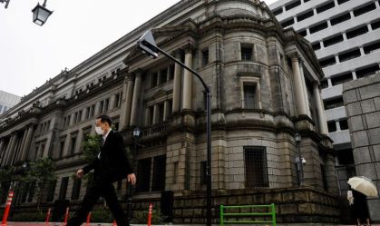 Homem de máscara protetora passa pela sede do Banco do