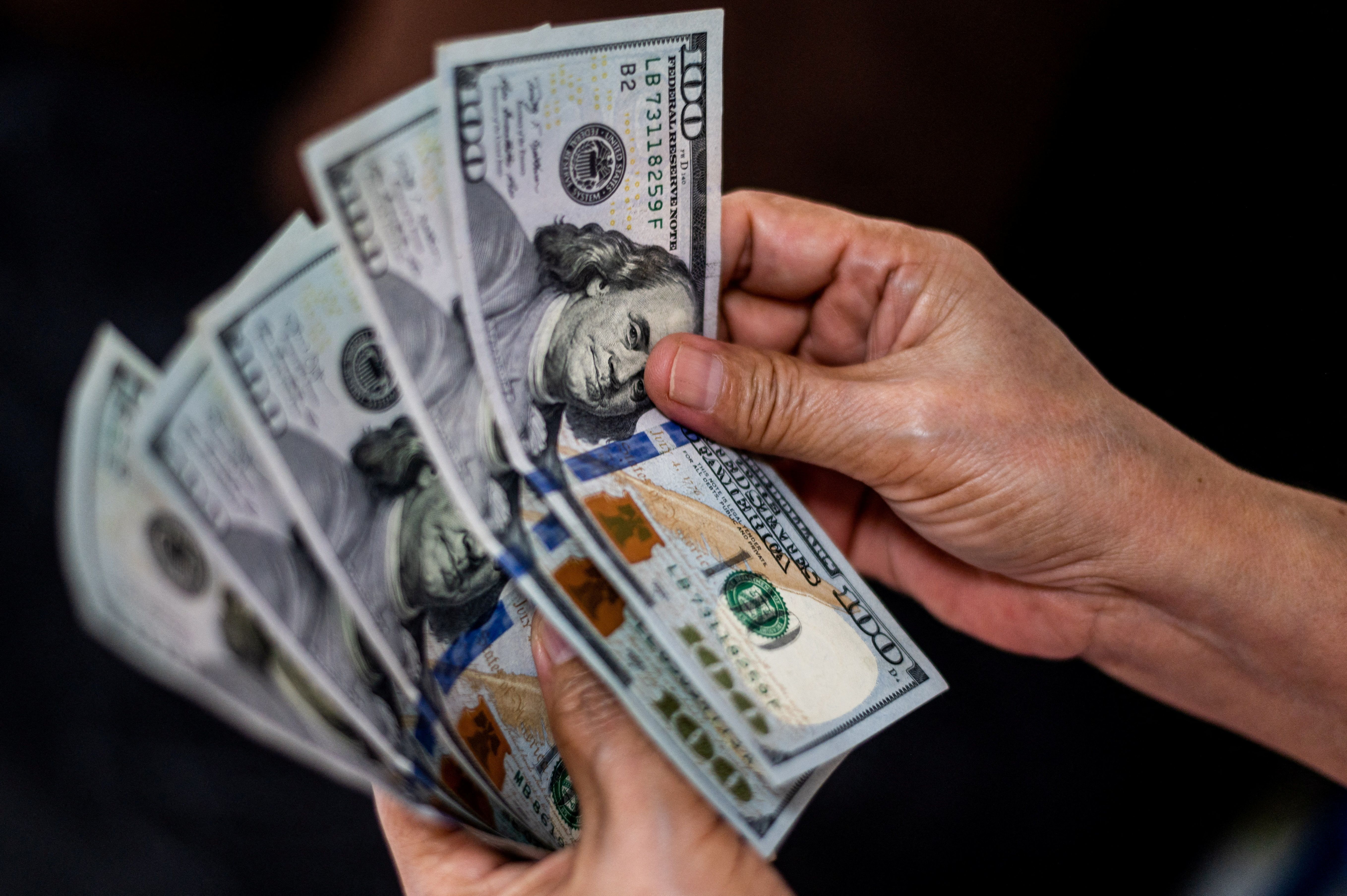 Pessoa segura notas de dólar
