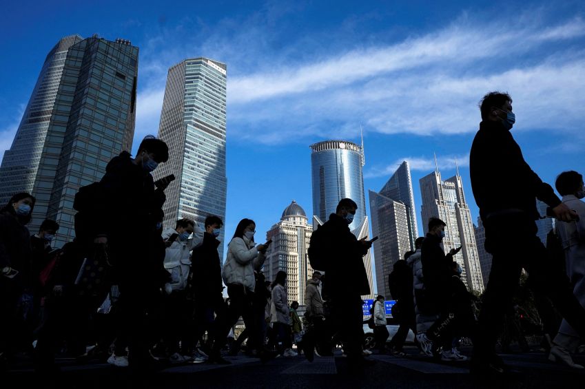 Pessoas atravessam a rua usando celular em distrito financeiro de Xangai, China / 28/02/2023 REUTERS/Aly Song