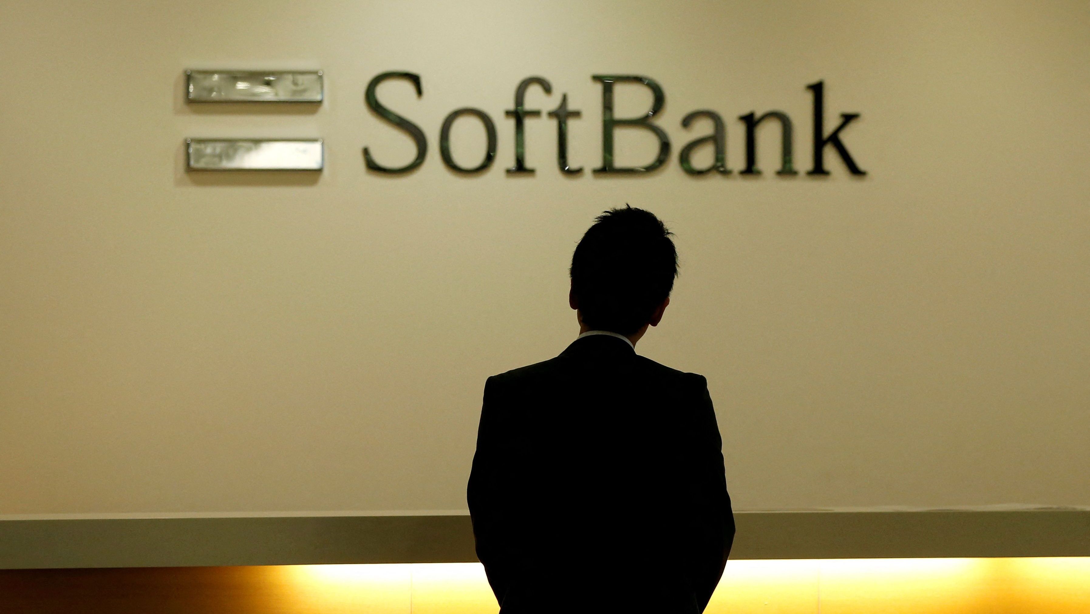 Homem olha para logotipo do SoftBank na sede da empresa em Tóquio