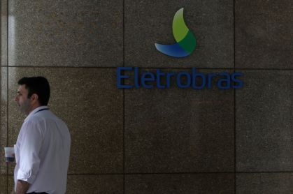 Pessoa perto do logo da Eletrobras, no Rio de Janeiro, Brasil