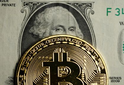 Representação do Bitcoin em cima de uma nota de dólar