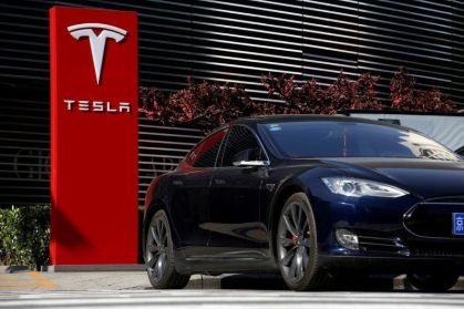 Um carro da Tesla carrega em uma estação de recarga em Pequim, China
