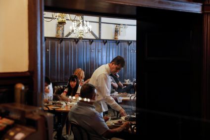 Garçom serve clientes em restaurante no Brooklyn, cidade de Nova York, EUA