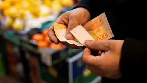 Cliente de mercado conta notas de peso argentino em Buenos Aires