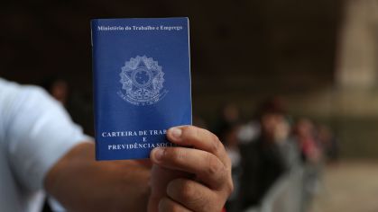Homem mostra carteira de trabalho em São Paulo