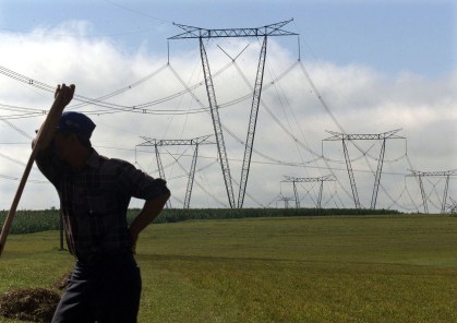 Trabalhador diante de torres de transmissão de energia em Itaipu