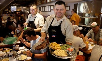 Garçom mostra pratos em restaurante do Rio de Janeiro
