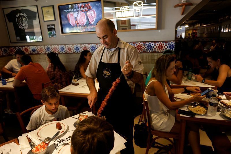 Garçom serve clientes em restaurante no Rio de Janeiro
