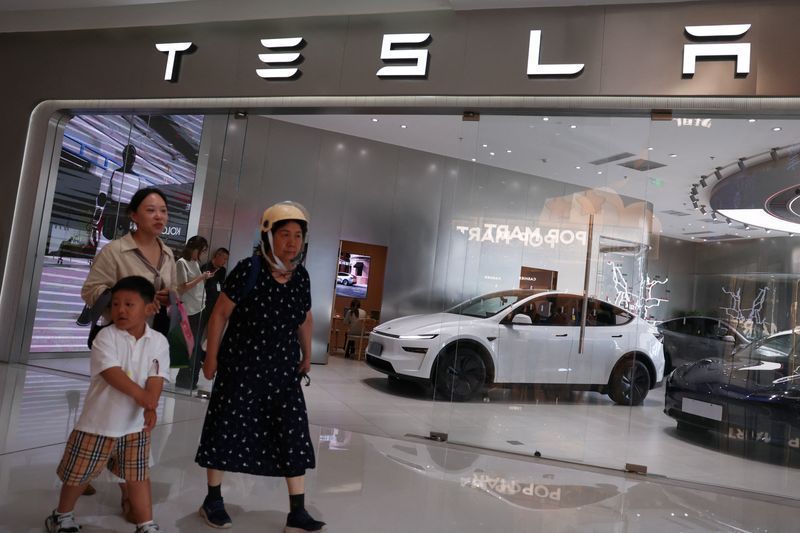 Pessoas passam por uma loja da Tesla em um shopping