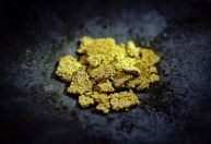 Ouro recua, mas fica próximo das máximas com incertezas econômicas