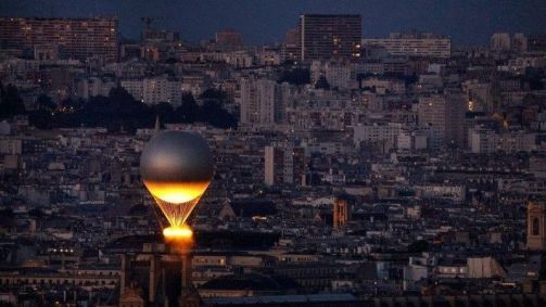 Pira olímpica voa sobre Paris presa a um balão